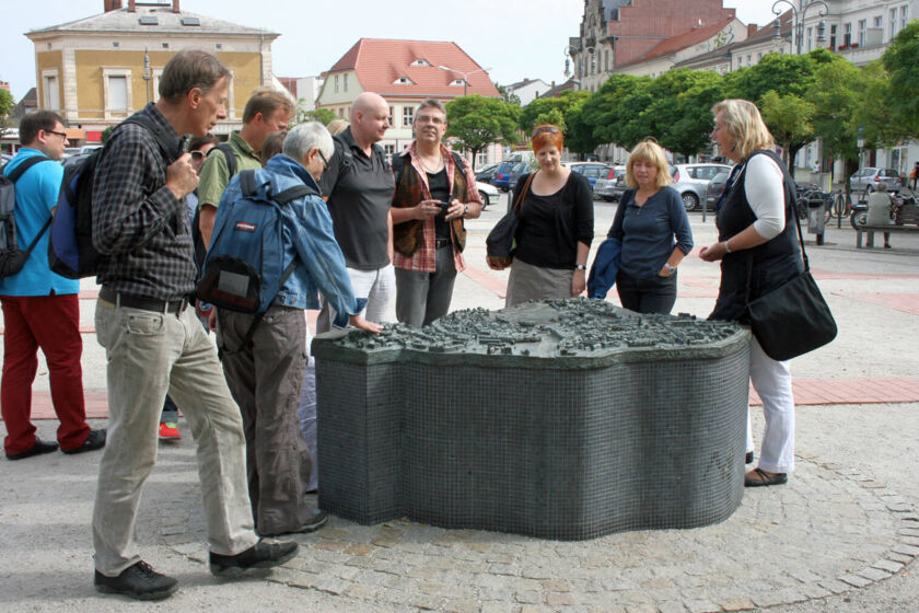 Ein Stadtführer zeigt den Touristen das historische Denkmal am Neustädtischen Markt